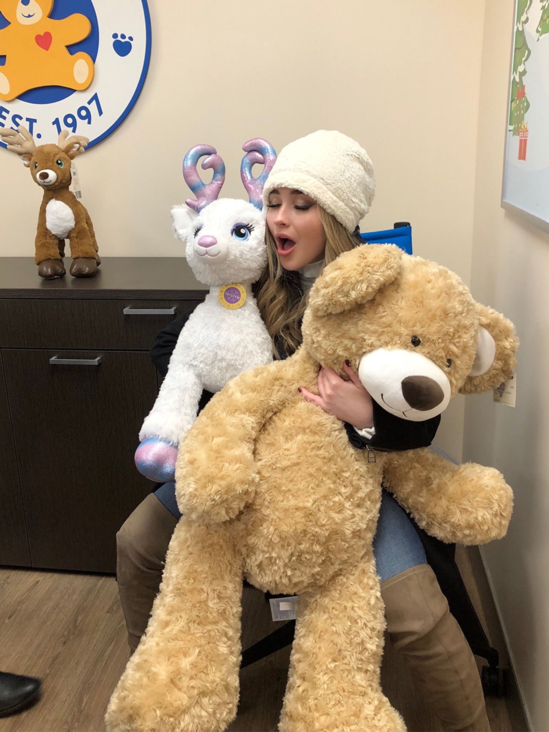 Sabrina Carpenter poses with plushies