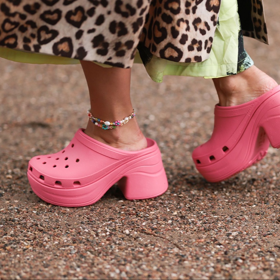 A woman wearing pink platform Crocs