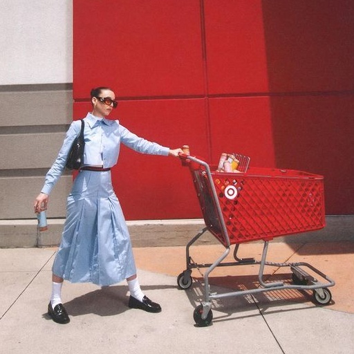 Emma Chamberlain holding a red Target shopping cart