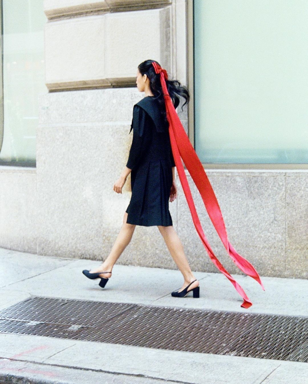 A model wearing a red bow in her hair