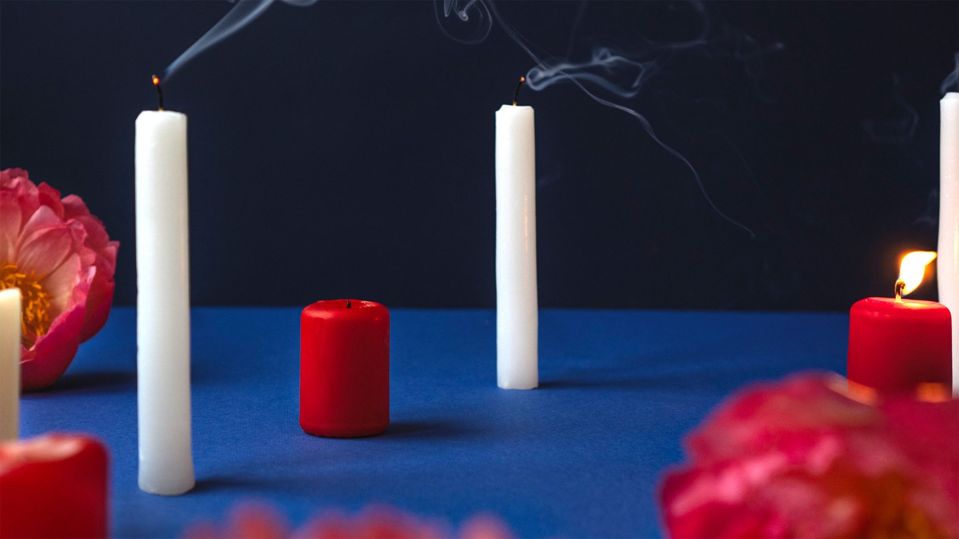 White and red candles on a table with flowers