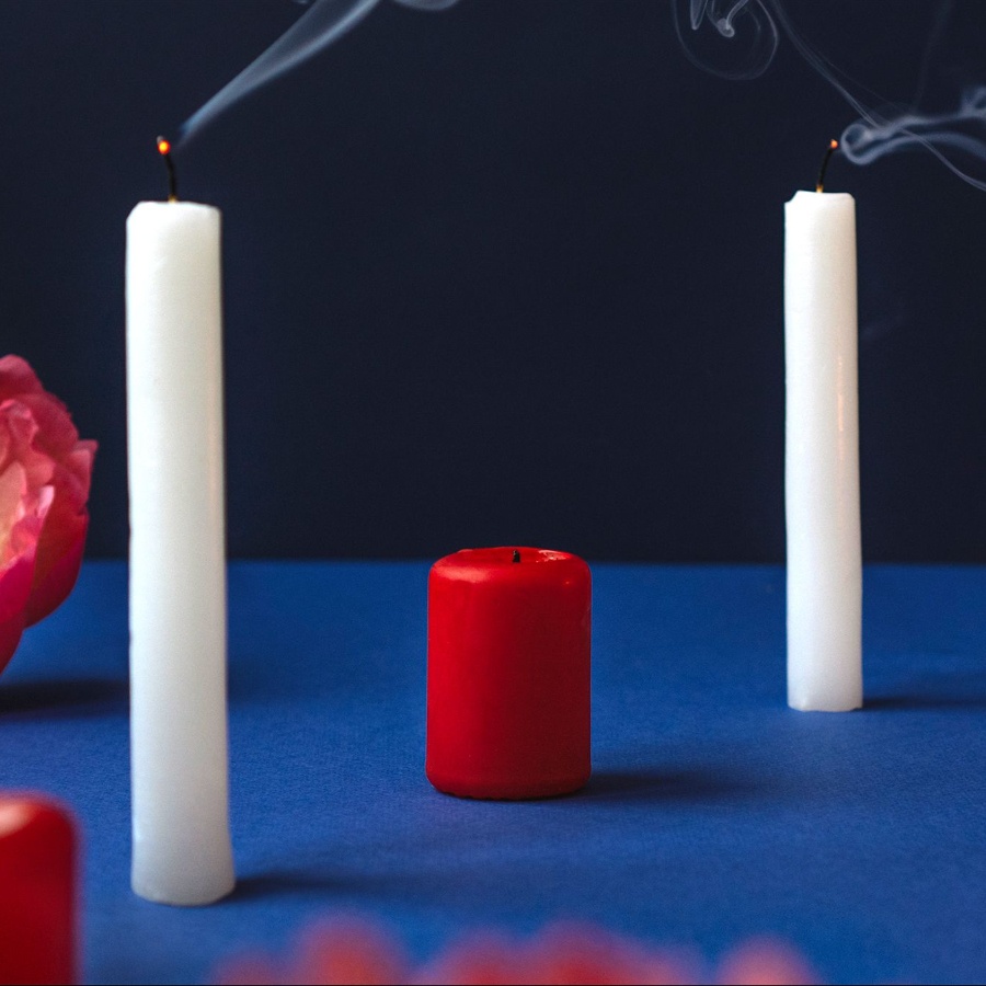 White and red candles on a table with flowers