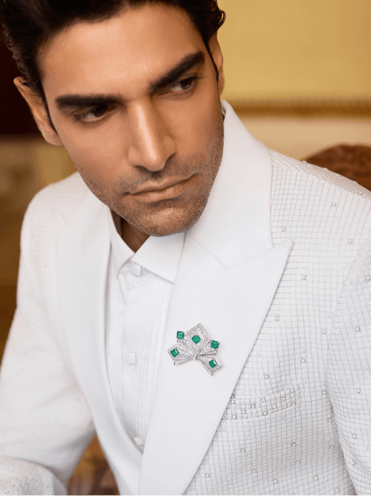 A model in a white suit and brooch by Manish Malhotra High Jewellery